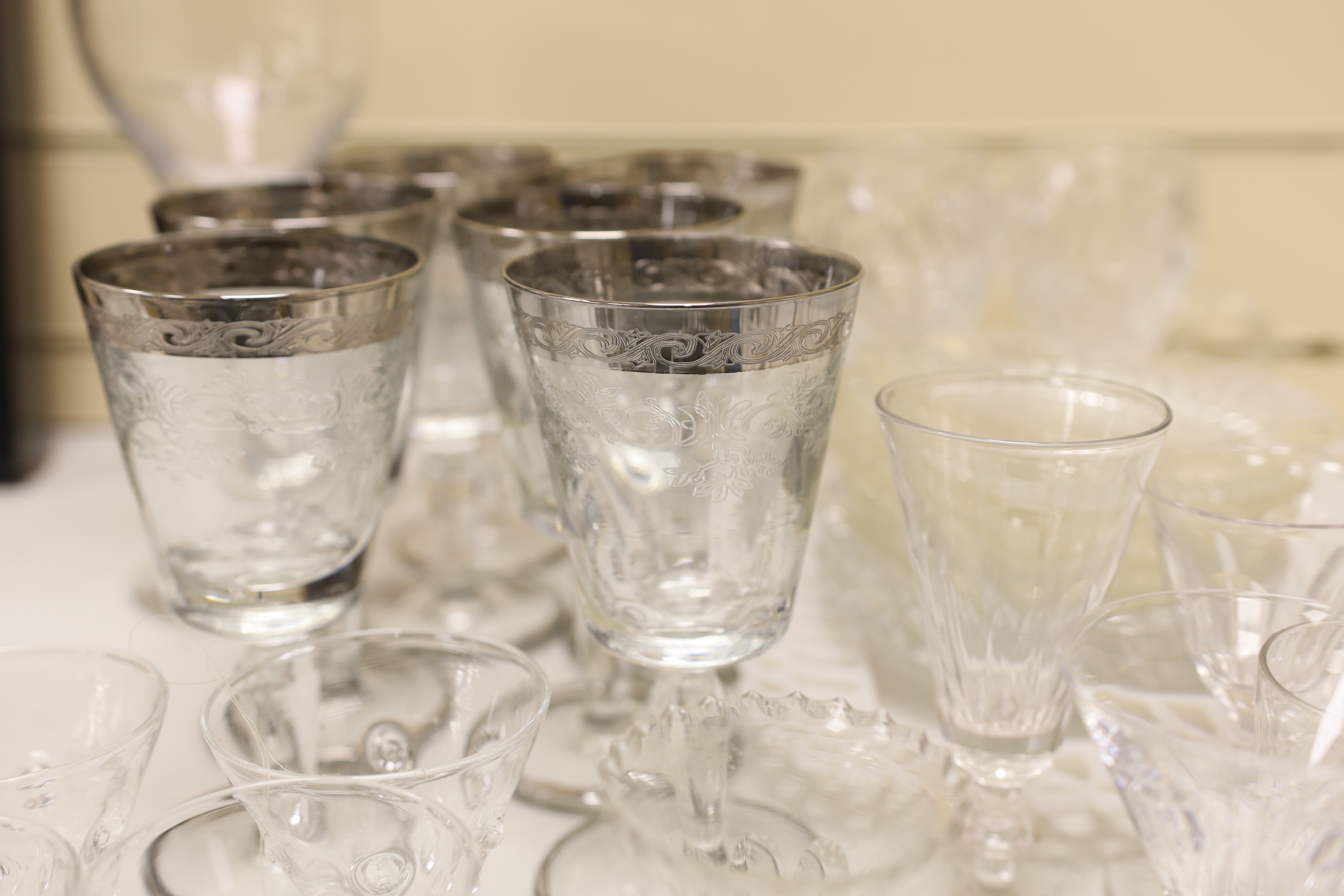A part suite of etched and silver banded wine glasses together with other glassware